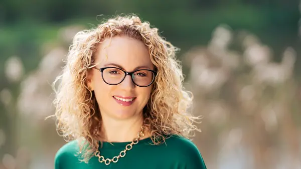 Photo of Nicola Green, smiling woman with blonde curly hair